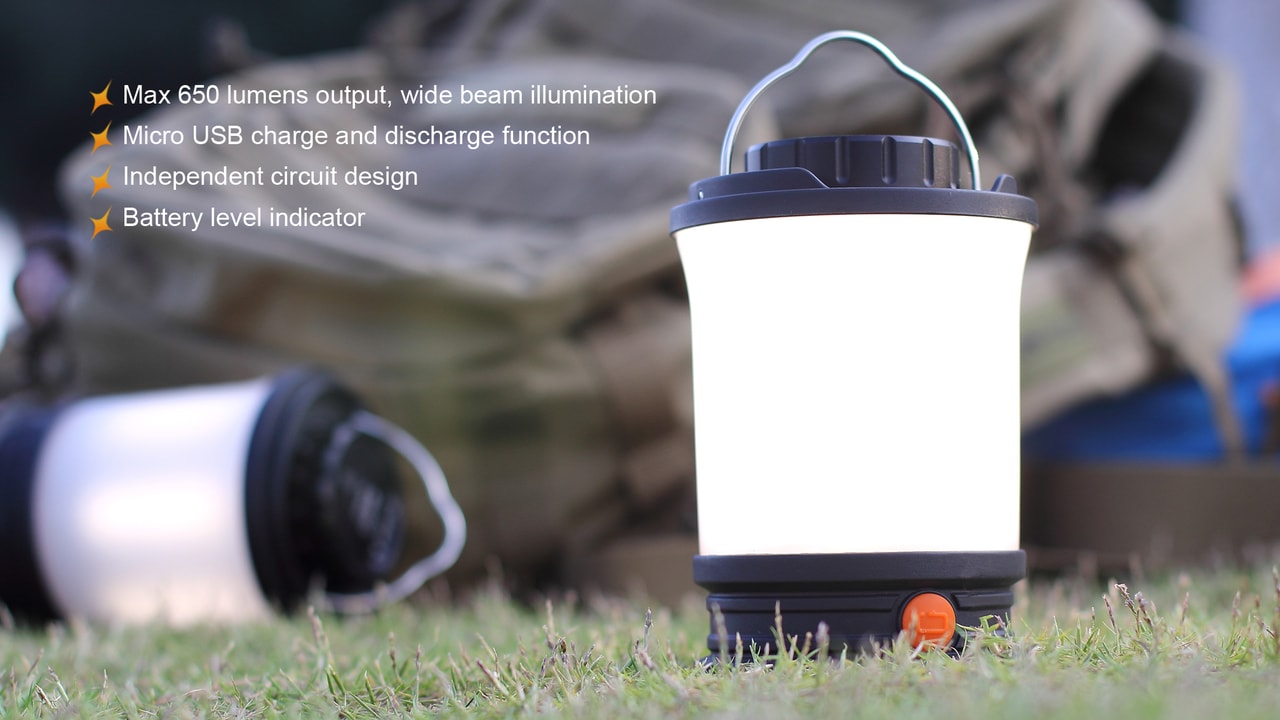 Portable lantern with charging cable on grass, features listed above.