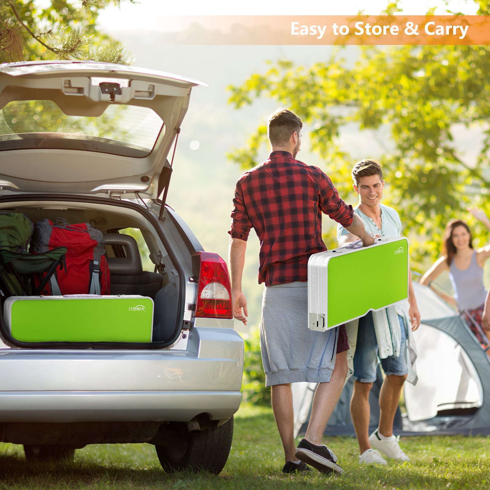 People with green portable furniture pieces near an open car trunk outdoors.