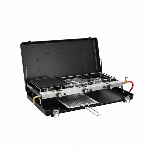 A portable folding camping stove set inside an open black hard case, shown on a clean white background. The stove features a black flat griddle, a three-burner stainless steel burner, a metal grill grate, and brass and red gas valve connectors.